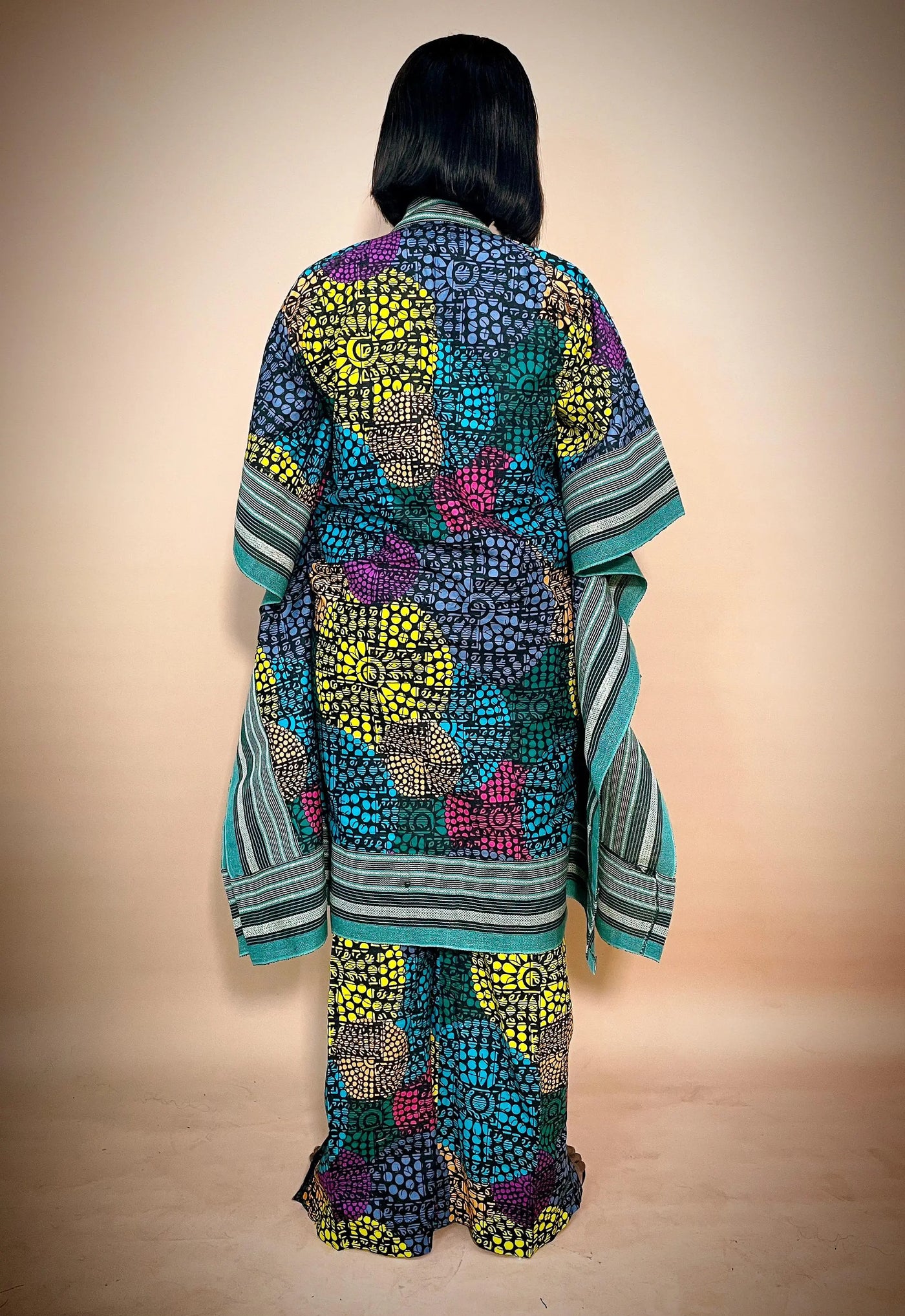 Back view of a person wearing a colorful patterned African Kimono & Palazzo Two Piece wera on a beige background
