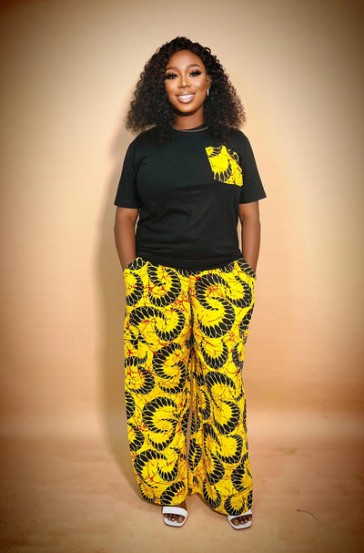 Woman wearing our African Print 2 Piece Set yellow patterned pants on a beige background