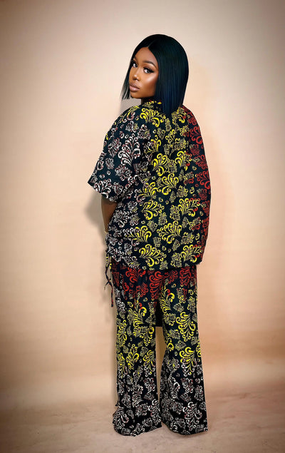 Woman wearing a colorful patterned African Two Piece Set against a beige background