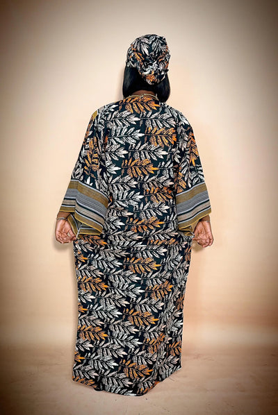 Back view of Woman wearing a long, patterned African ankara dress with a matching headscarf on a beige background