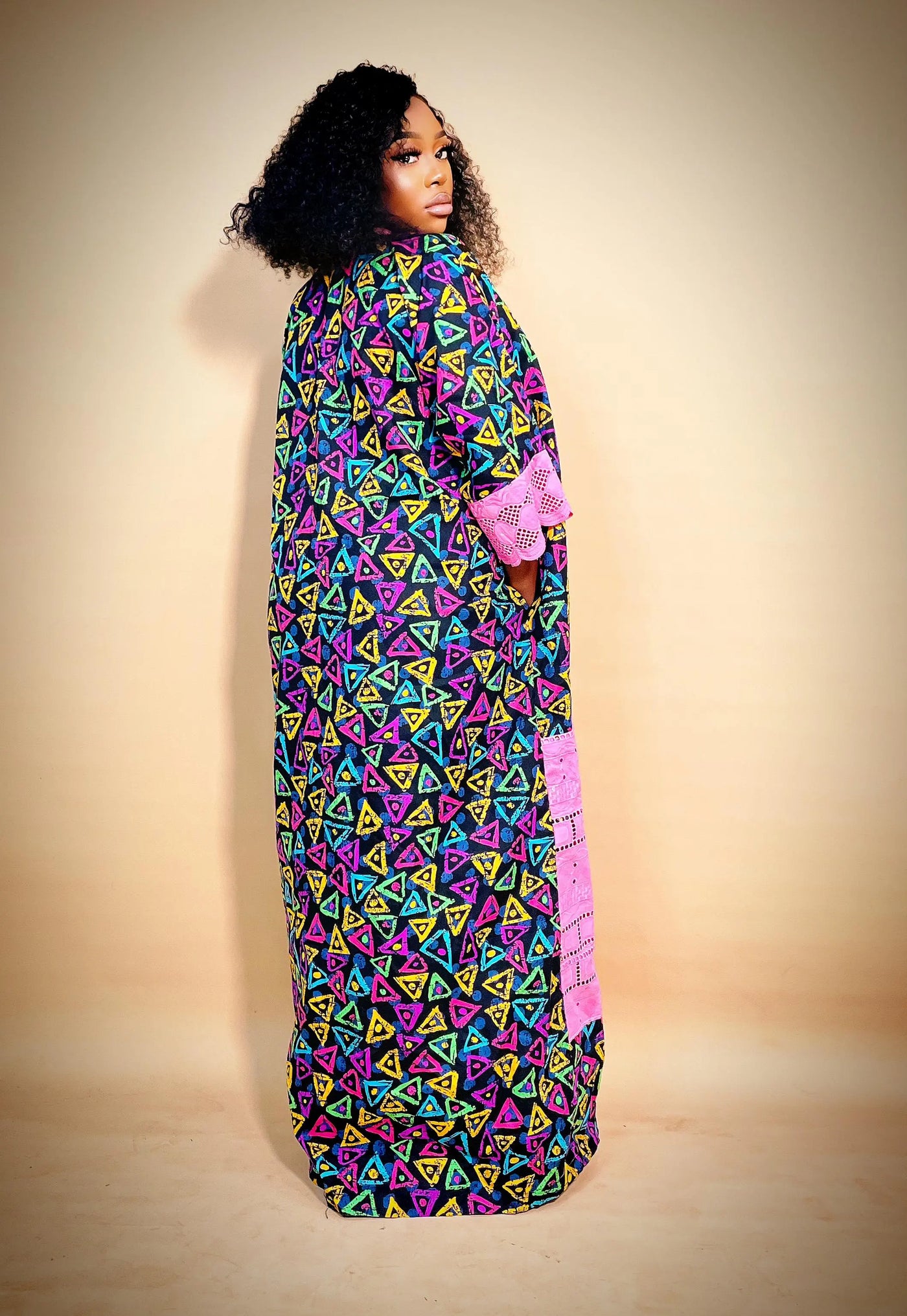 Woman wearing the Latest Ankara Bubu Gown Style with geometric patterns on a beige background