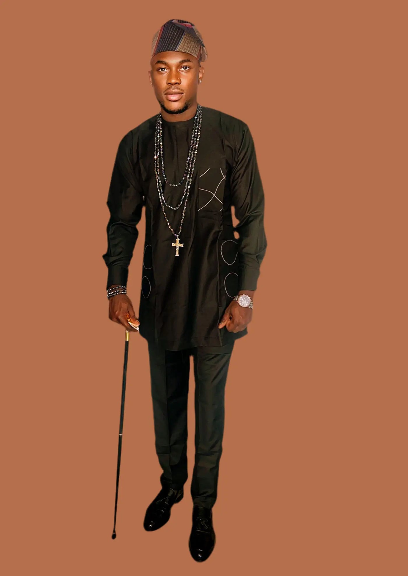 Man in black African Senator Long Sleeve Set  with accessories on a brown background