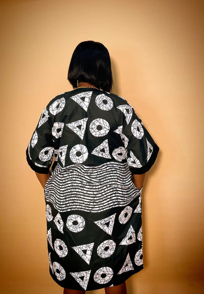Person wearing a black and white patterned outfit against a beige background