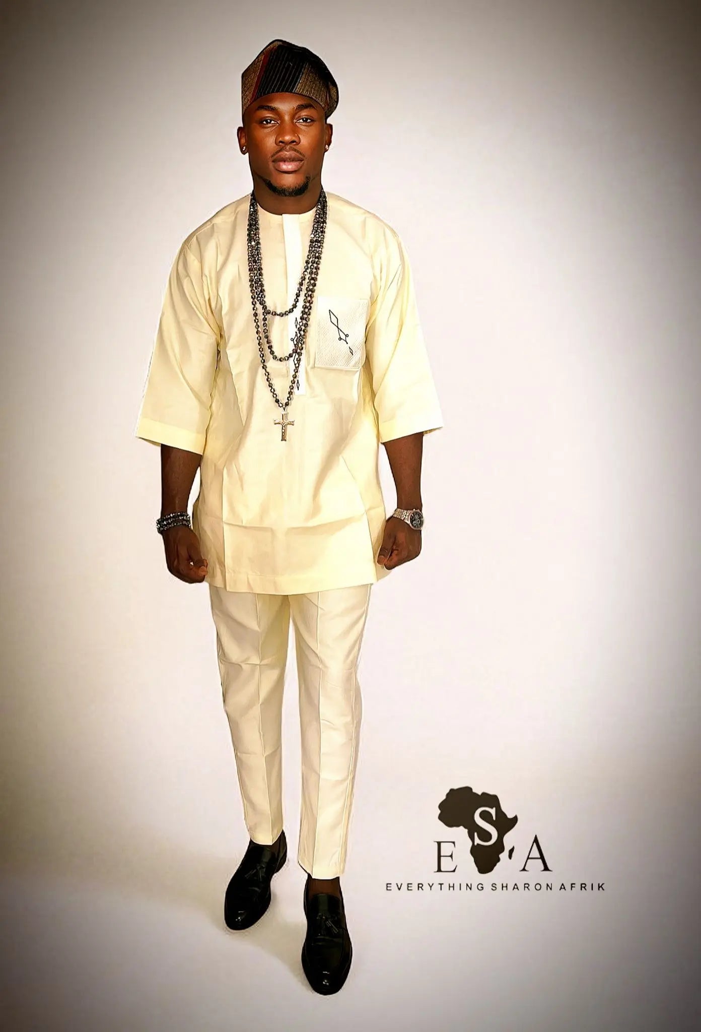 Man wearing a beige African Senator Wear for Men with a plain background
