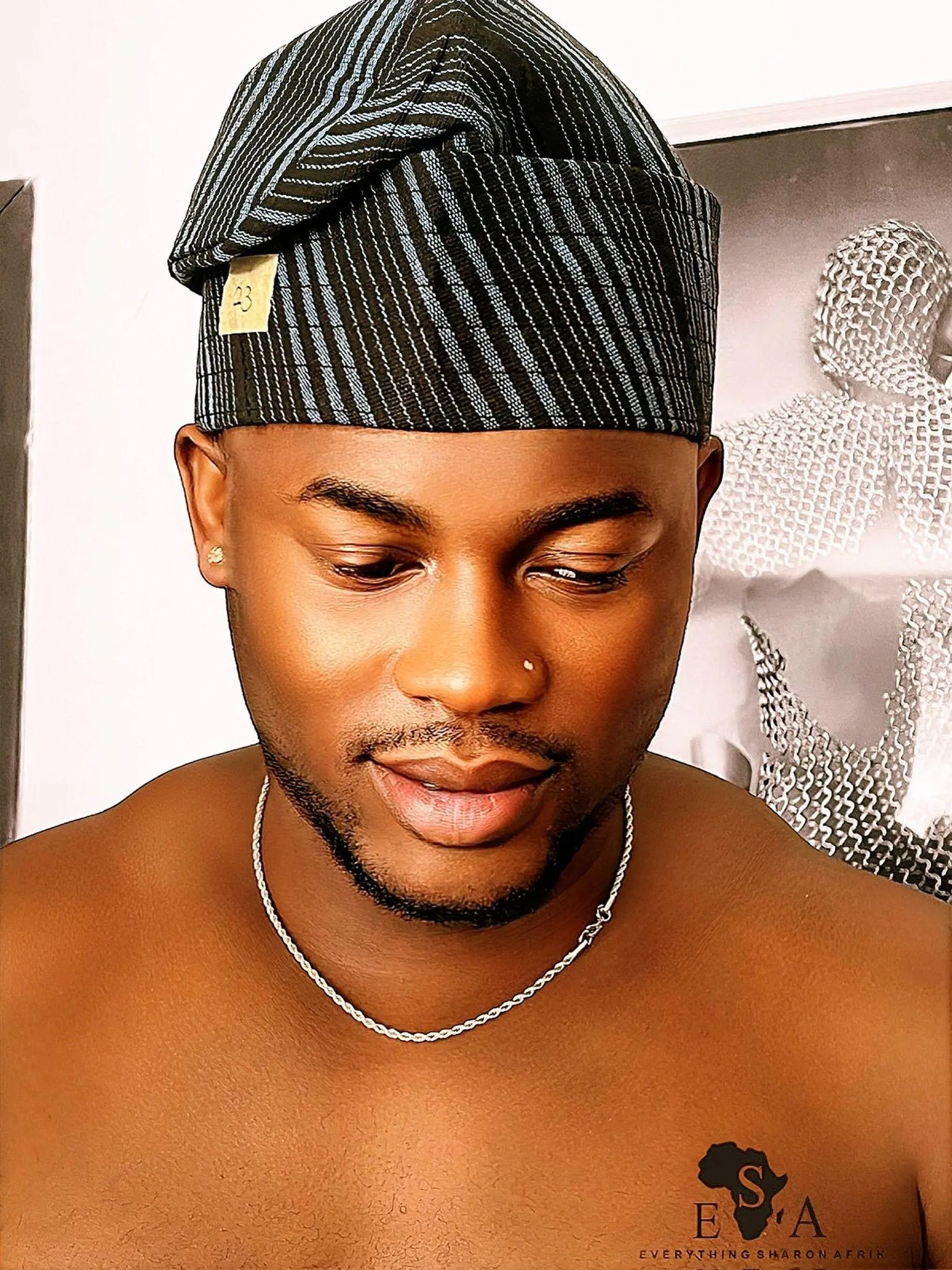 Man wearing a traditional Asooke cap with a blurred background