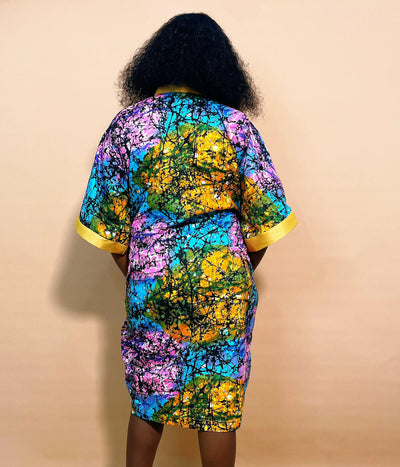 Back view of a woman wearing an African Multicolored Short Bubu Gown against a brown background