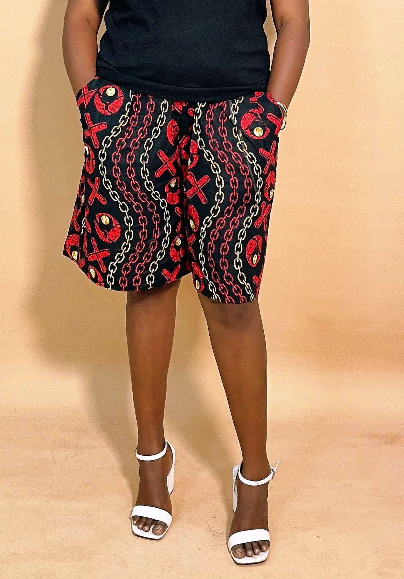 Woman wearing a black skirt with Ankara Print Short Baggy Pant and a white heel sandal on a beige background 