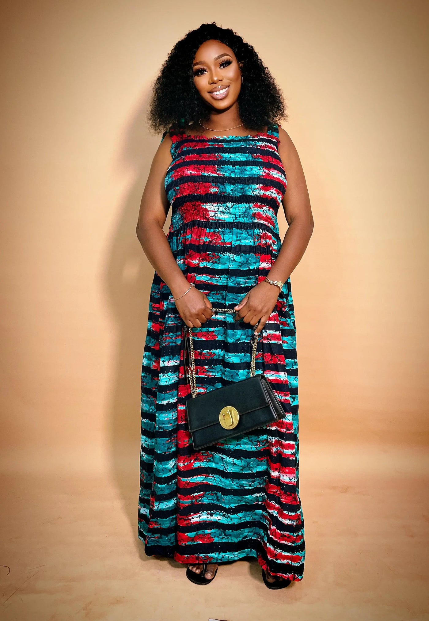 Woman wearing a colorful sleeveless African Print Maxi Dress on a beige background