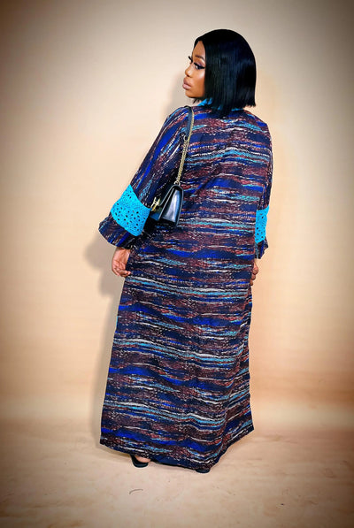 Woman wearing a long Ankara Bubu Gown with Blue Dry Lace against a beige background