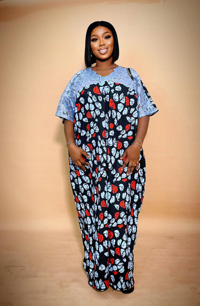 Woman wearing a long Ankara dress with net Lace with a plain background