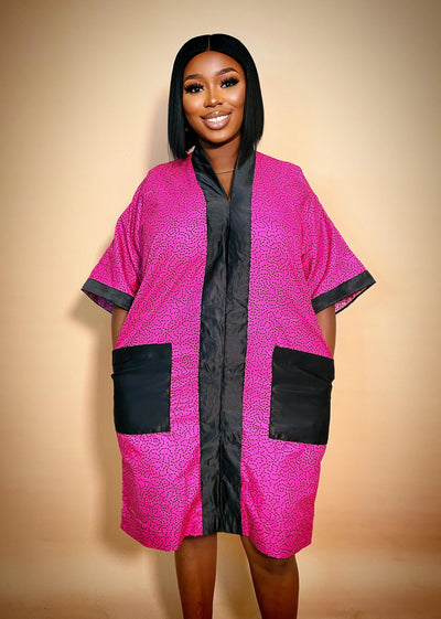 Woman wearing a pink and black patterned dress against a beige background