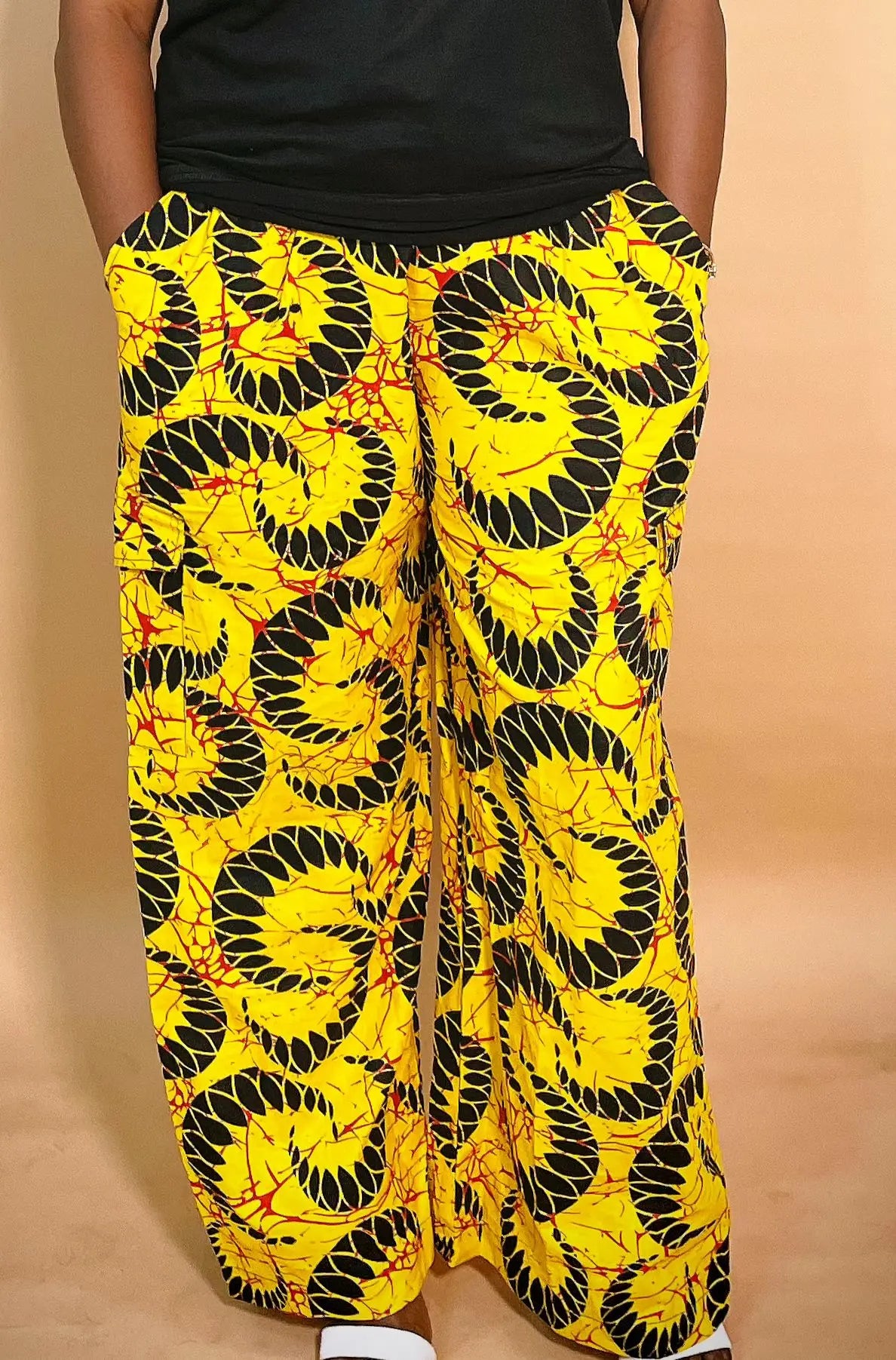 back view of a yellow patterned Ankara baggy pant with gold chain detail on a blurred background