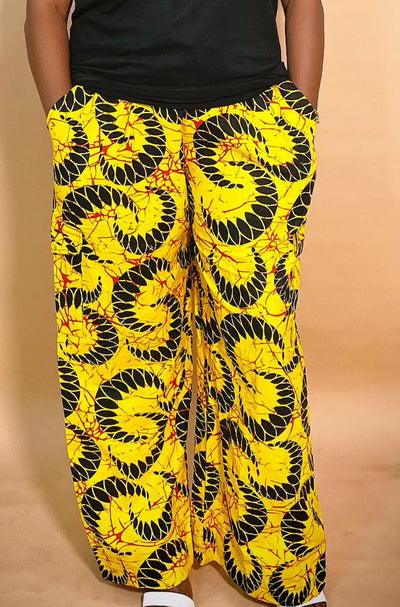 back view of a yellow patterned Ankara baggy pant with gold chain detail on a blurred background