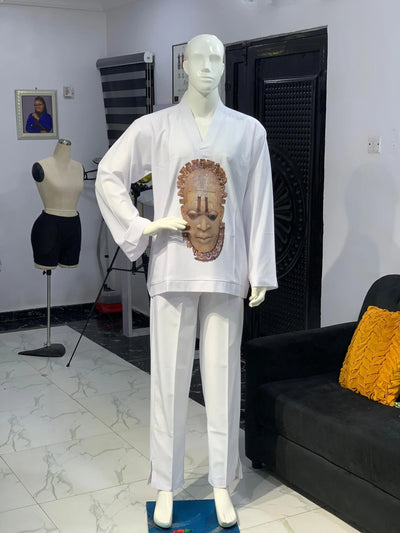 Mannequin wearing a white Long Sleeve Kaftan 2 Piece with a face design in a room with a couch and another mannequin.
